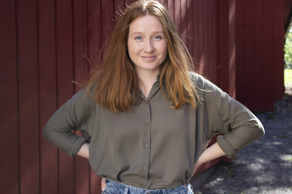 Porträtt av Ragna Stertman mot en röd vägg